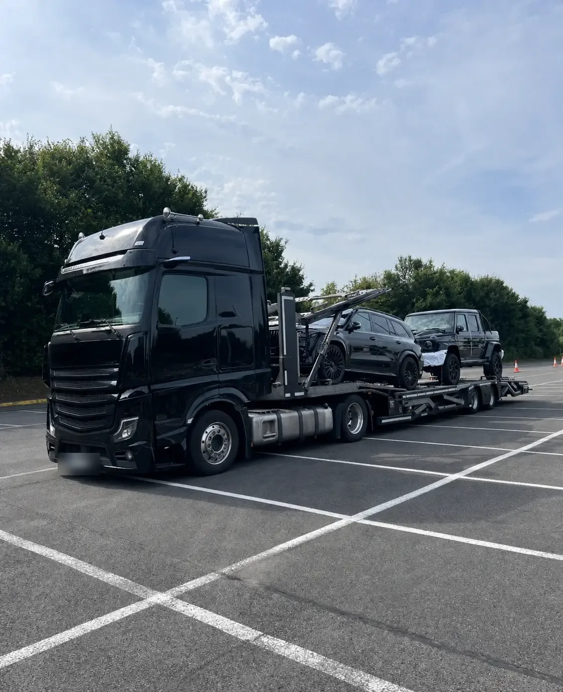 Black car transport truck carrying SUVs on a sunny day - brentalogistics.com
