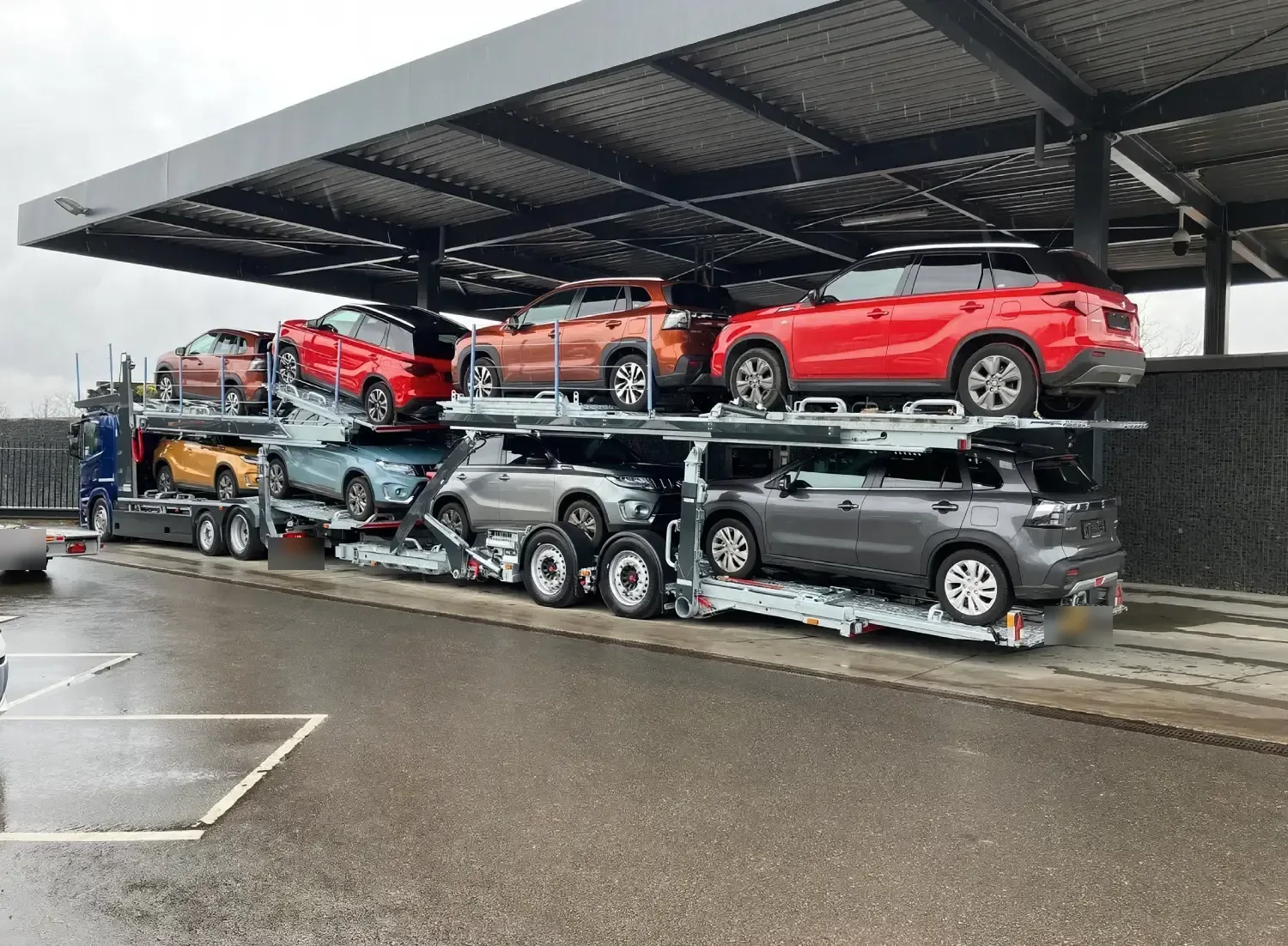 Doppelstöckiger Autotransporter mit roten und grauen Neuwagen unter einem Dach - brentalogistics.com